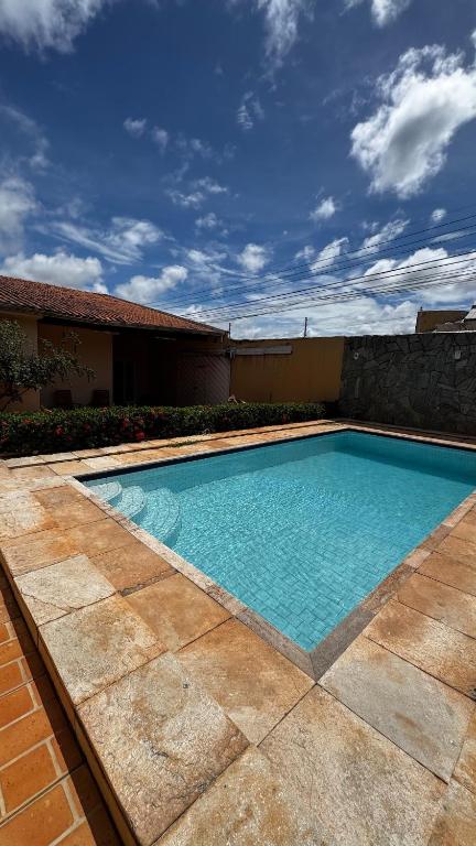 a swimming pool with blue water in front of a building at Casa com piscina 20 Leitos in Cuiabá