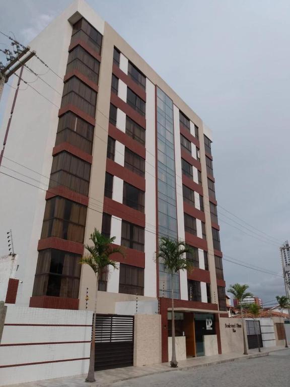 a tall building with palm trees in front of it at Boulevard Plaza Flat Mirante Apto 201 in Campina Grande