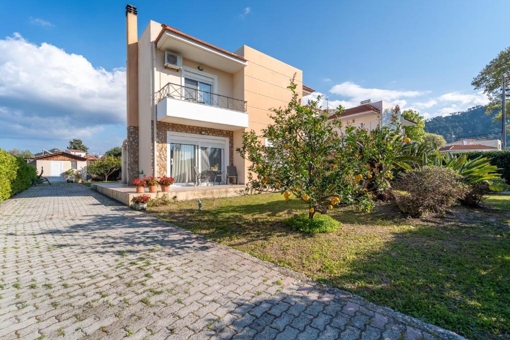 a house with a brick driveway in front of it at Filerimos Dream Villa in Ialysos