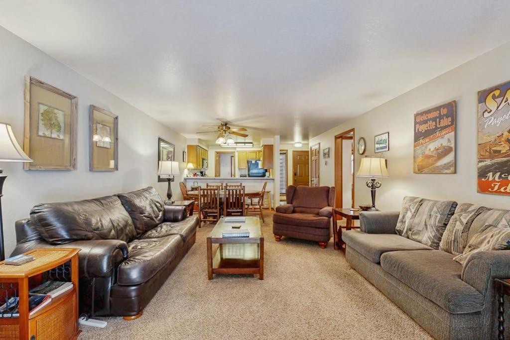 a living room with leather couches and a table at Golf Course Retreat - Pool Access Lake Views in McCall