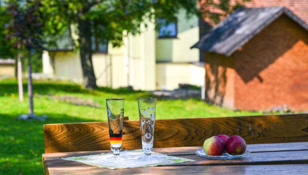 チェシンにあるSweet Family Homeの木製テーブルの上にリンゴをかけたグラス2杯