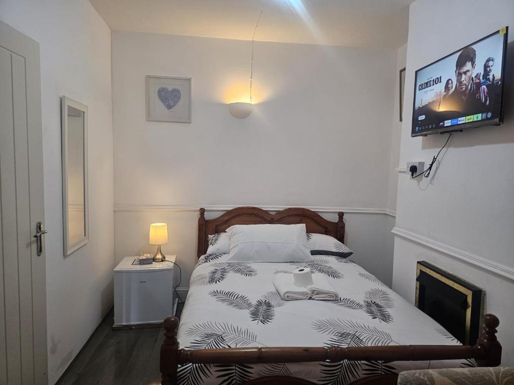 a bedroom with a bed with a tv on the wall at Seraphic Homes Medway Kent in Gillingham