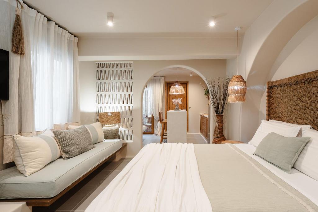 a bedroom with a large white bed and a couch at Chic Elysium in Naxos Chora