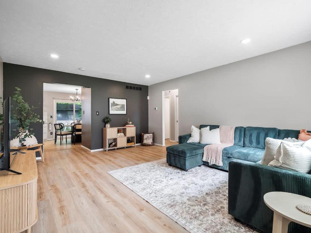 a living room with a blue couch and a table at Beautiful Ranch with Outdoor Patio and Room for 6 in Munroe Falls