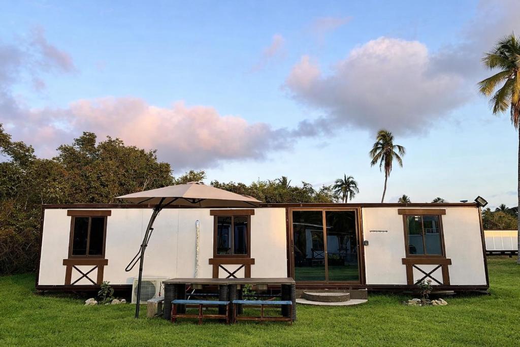 a small house with an umbrella in the grass at Casa Bonassola, Barra de Navidad in Barra de Navidad