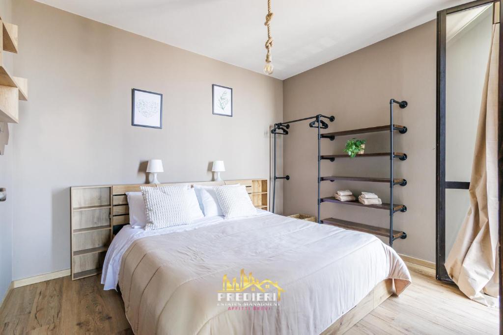 a bedroom with a large bed with white sheets at Sest0la Centro Loft con Vista sul Paesaggio in Sestola