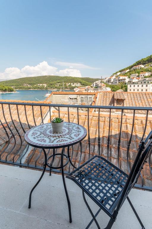 a table and chairs on a balcony with a view of the water at Apartments Sonja in Pučišća