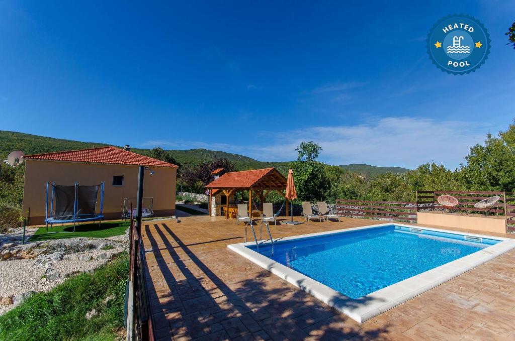 a swimming pool in front of a house at Villa Strikina kuca in Slivno
