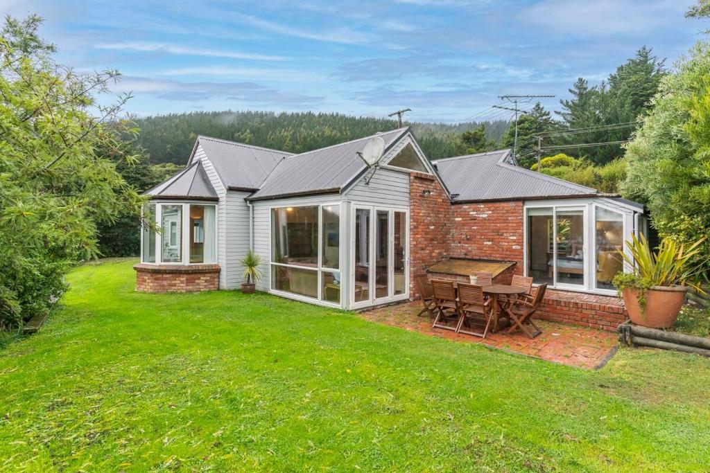 a brick house with a picnic table in a yard at Waitati Retreat in Waitati