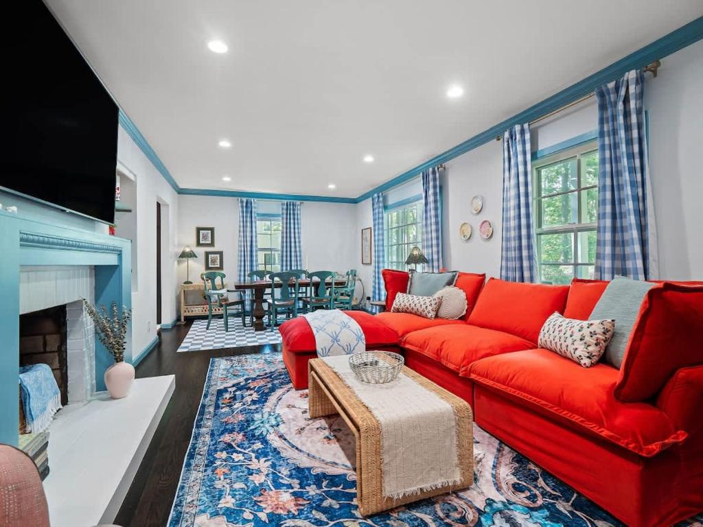 a living room with a red couch and a fireplace at Renovated Cottage - Game Room - Fire Pit - Sleeps 8 in Moreland Hills