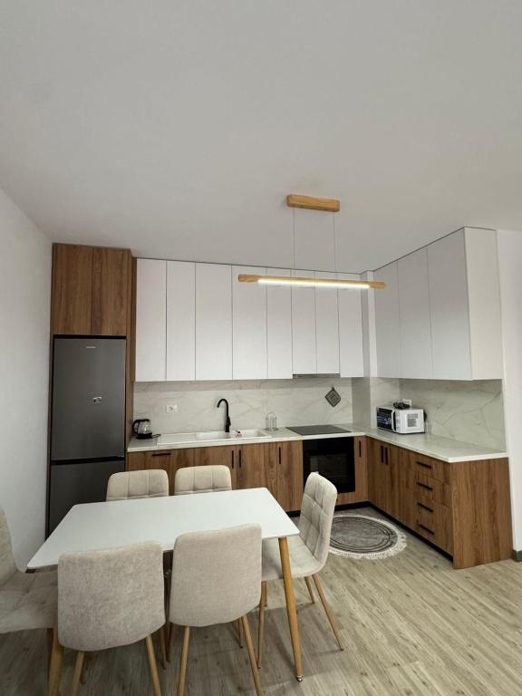 a kitchen with a table and chairs in a kitchen at Poshi Apartment in Krujë