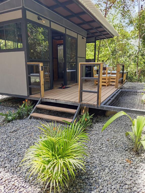 a home with a wooden deck and a house at Glamping las palmas in Nimaima