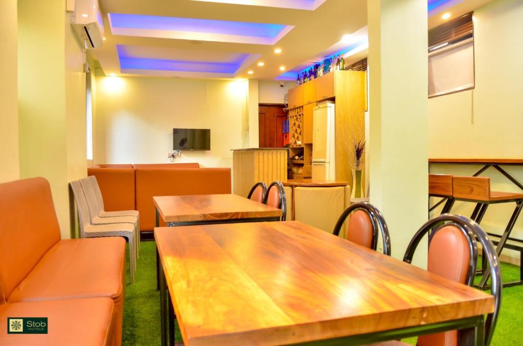 a restaurant with tables and chairs and a kitchen at STOBHOTELs in Kasangati