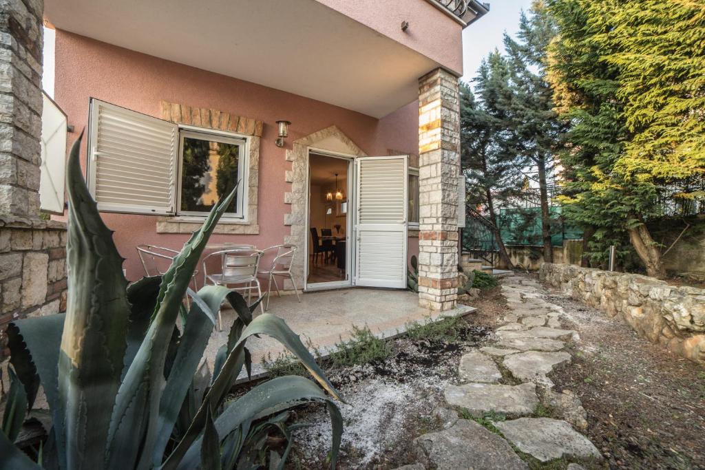 różowy dom z kaktusem przed nim w obiekcie Villa Lugano w Rovinj