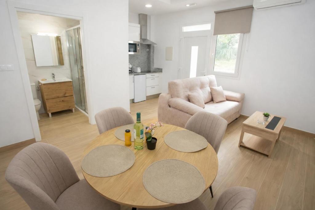 a living room with a table and chairs and a couch at Apartamentos Turísticos El Cholo in Fisterra