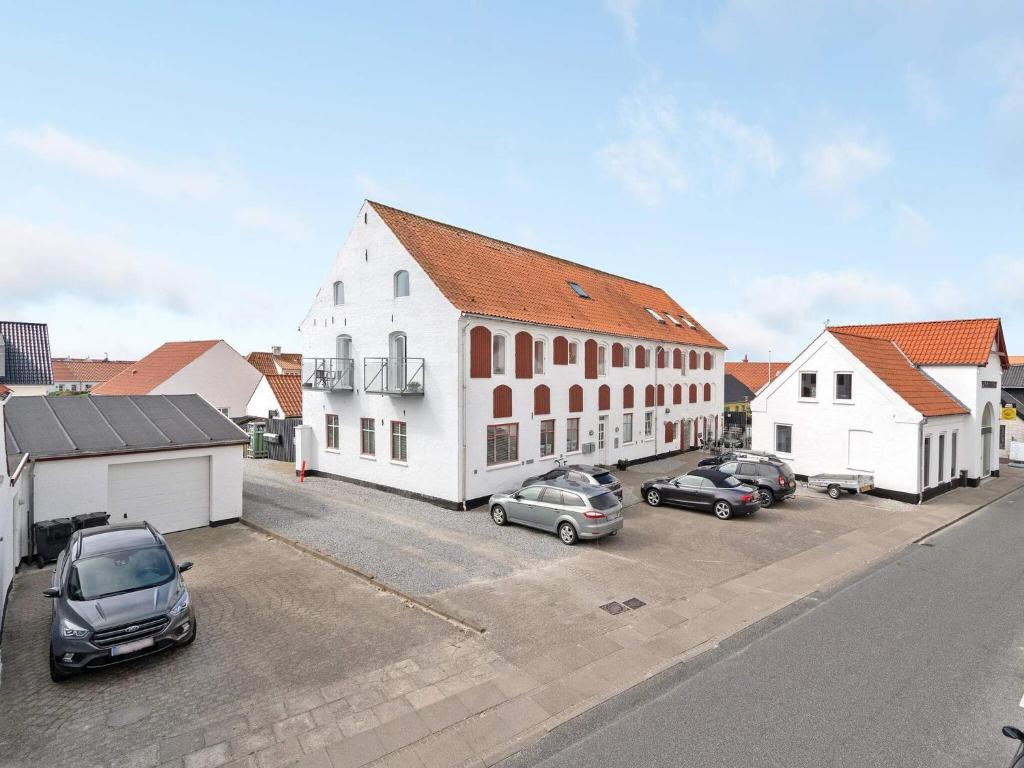 a large white building with cars parked in a parking lot at Two-Story Loft with Large Terrace in Løkken