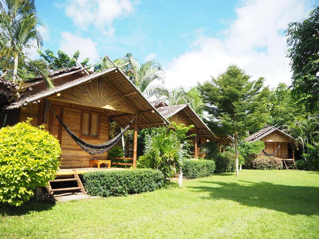 a house with a hammock in front of it at Pai Country Hut in Pai