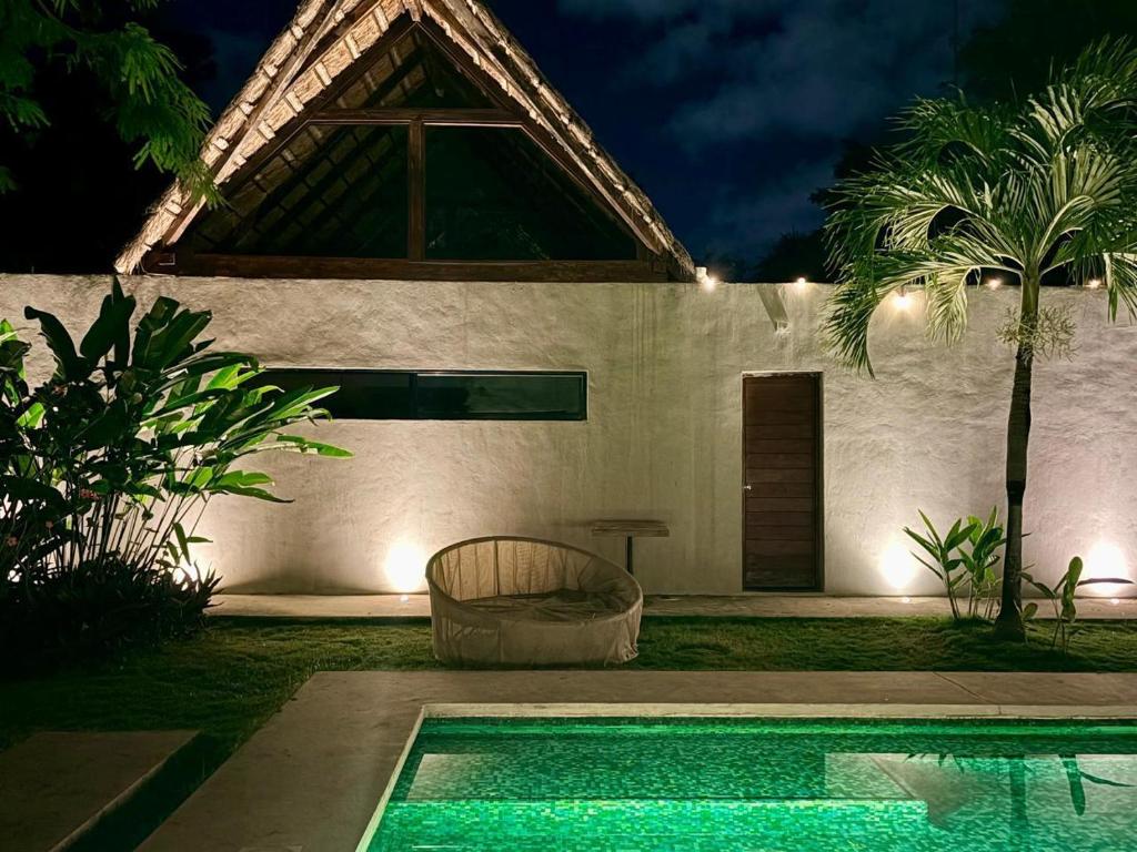 a swimming pool in front of a house at night at Aqua Viva in Tulum