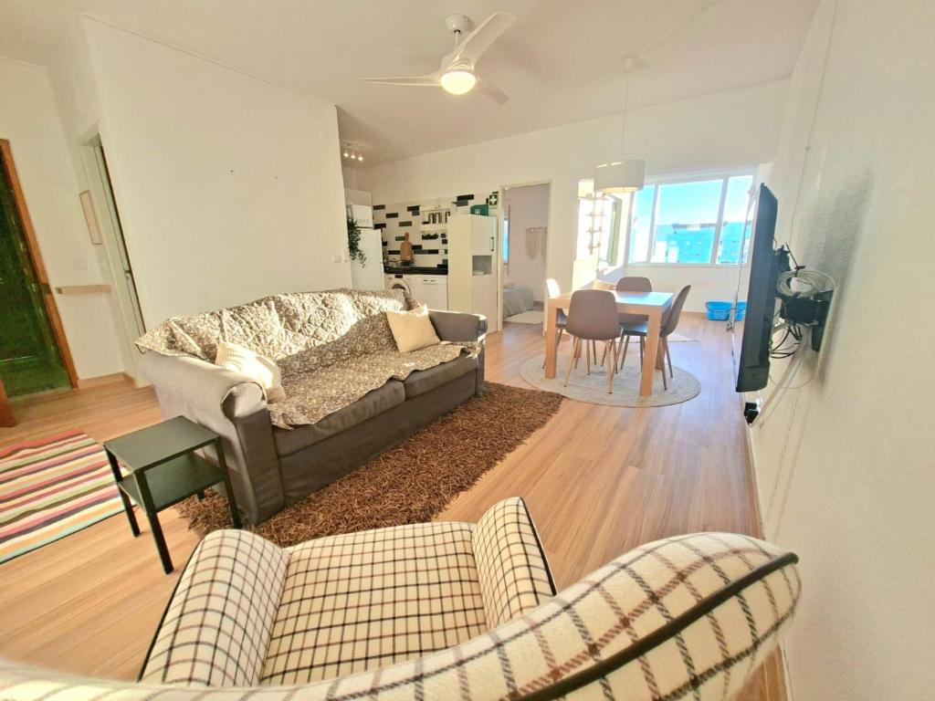 a living room with a couch and chairs and a table at Arrifana Sea Stay in Aljezur