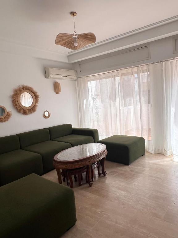 a living room with a green couch and a table at Central Urban Terrace in Rabat
