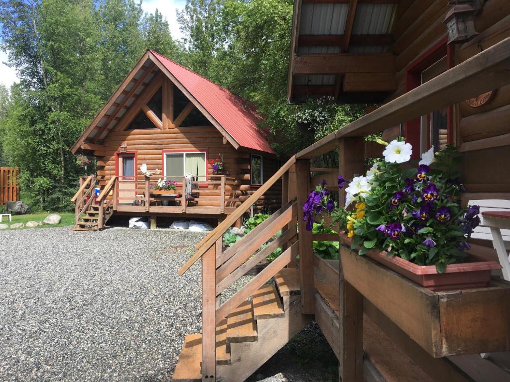 a cabin with a porch and flowers on the fence at Hatcher Pass Cabins in Palmer