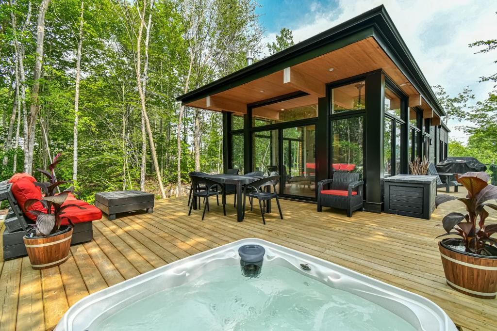 ein Whirlpool auf einer Terrasse mit einem Haus in der Unterkunft Chic & Bois in La Conception