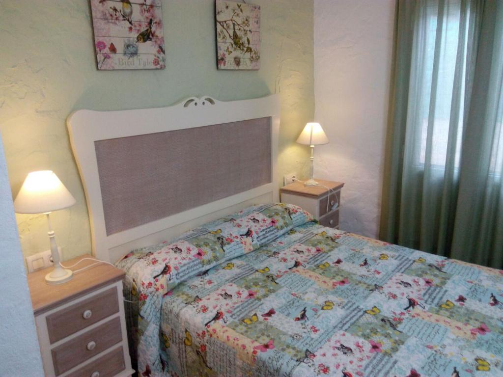 1 dormitorio con 1 cama con edredón en Mirador de Mulera, en Ubrique