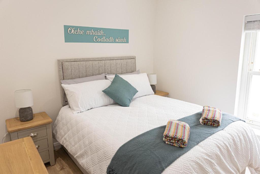 a bedroom with a bed with two pillows on it at Derry City Centre 1 & 2 Bedroom Modern Apartments in Derry Londonderry