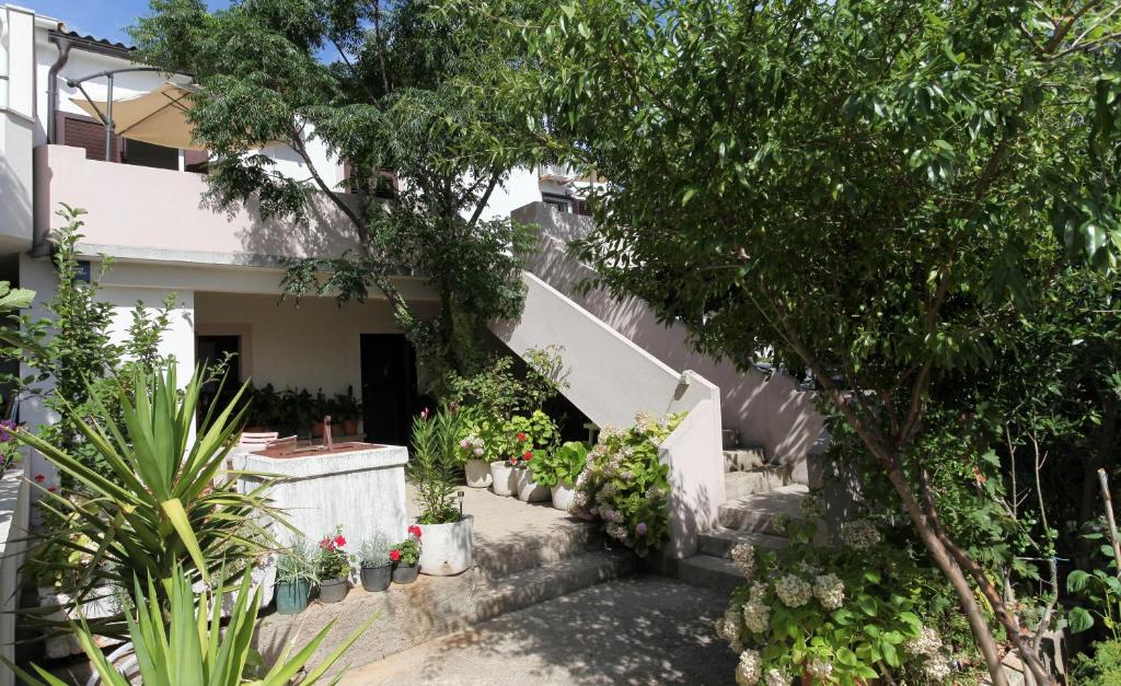 a house with a bunch of plants on the stairs at Apartment Mandre 4105a in Kolan