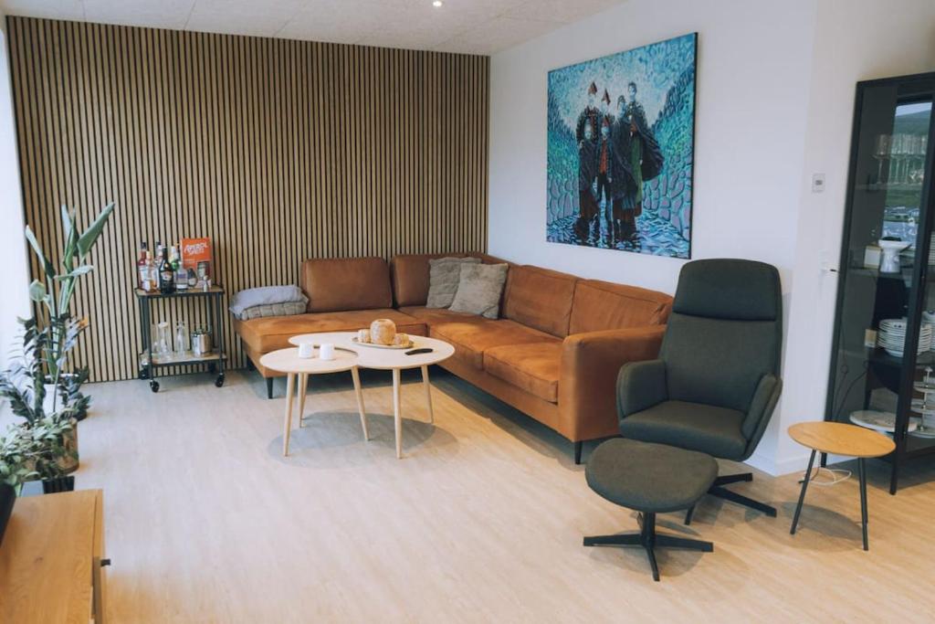 a living room with a couch and a table at High end 3 BR Spacious Villa for 6 guests in Norðskáli
