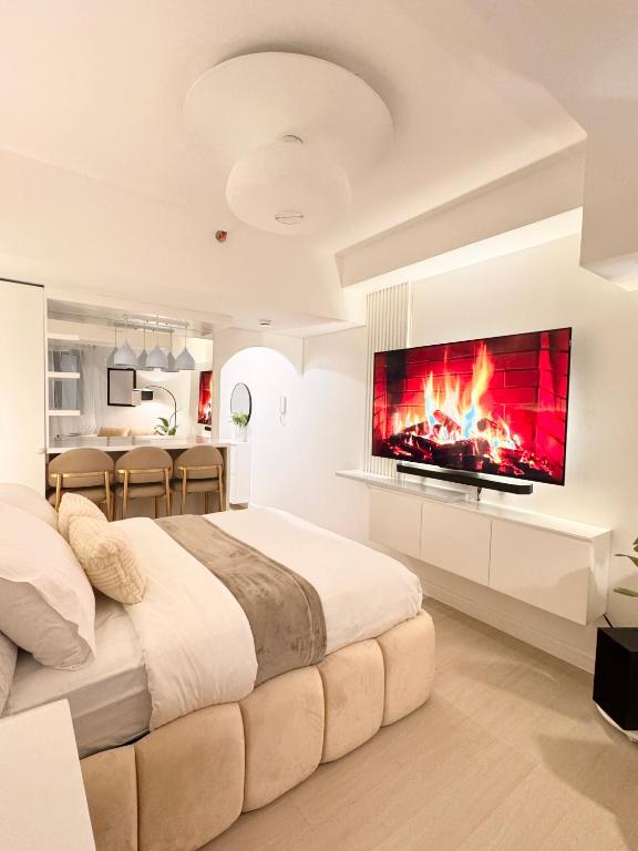 a bedroom with a large bed with a fireplace at Cloud Haven Suite at Azure North Pampanga in San Fernando