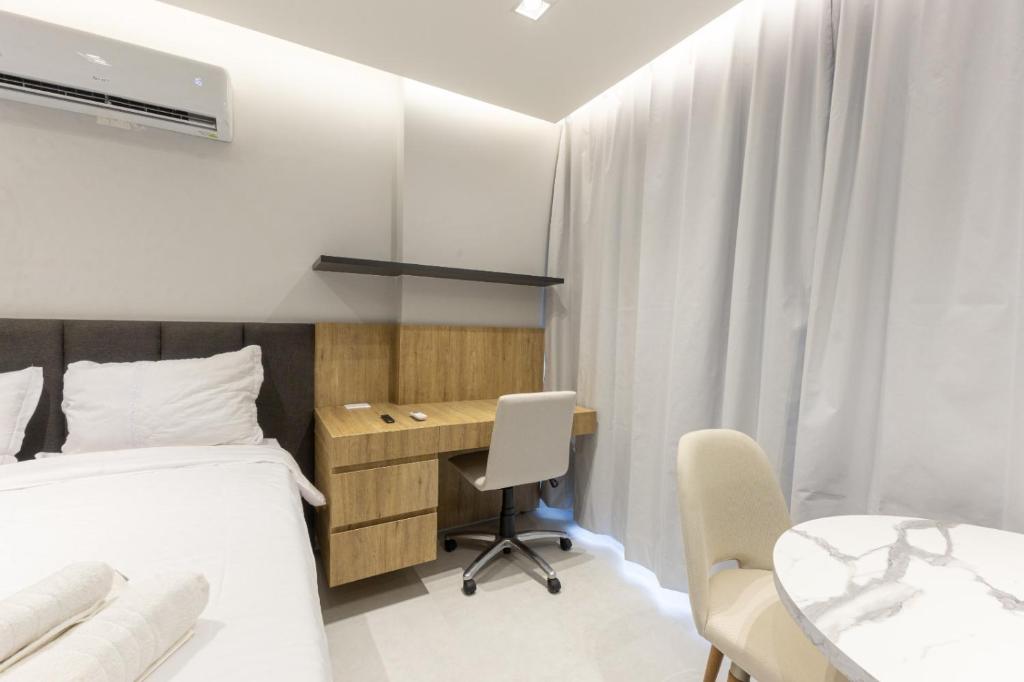 a bedroom with a bed and a desk and a table at City House 204 in Barreiras