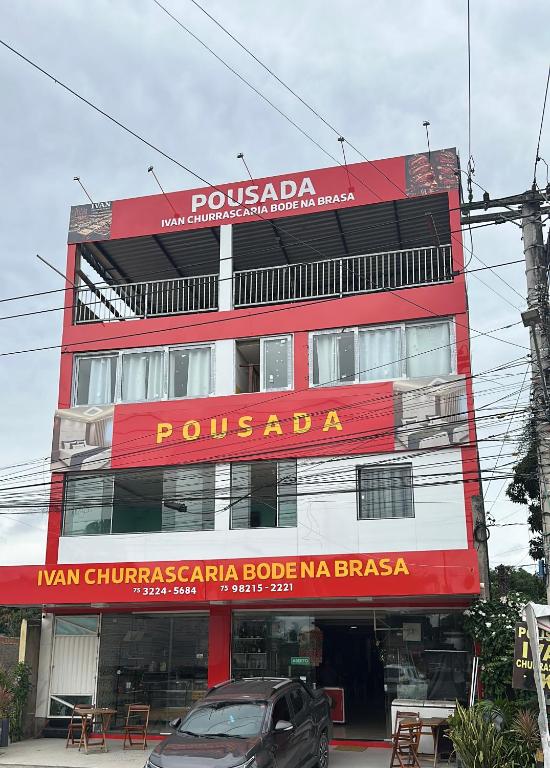 a red building with a sign on the side of it at Ivan Pousada e Churrascaria Bode na Brasa in Feira de Santana