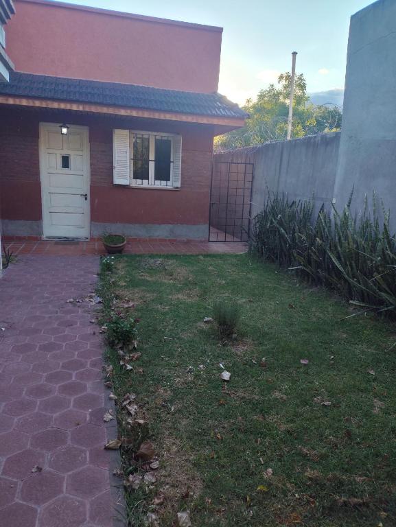a small house with a yard with a driveway at Casa chalet cerca nodo y estadio in Santiago del Estero