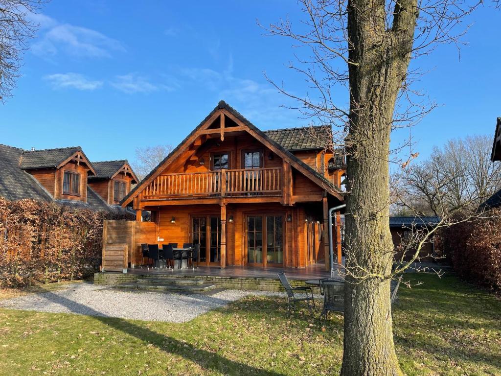 a large wooden house with a tree at Forest Villa, Rural Twente in Den Ham