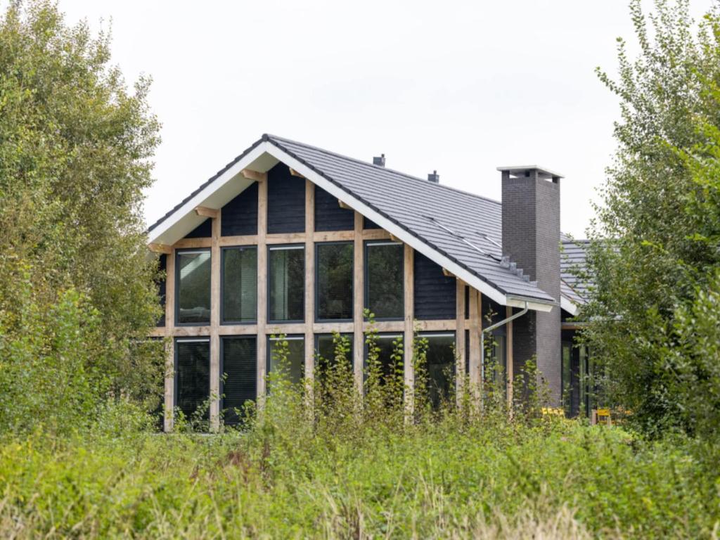 a house with a lot of windows at Villa with Heated Pool, Sauna in Aalten