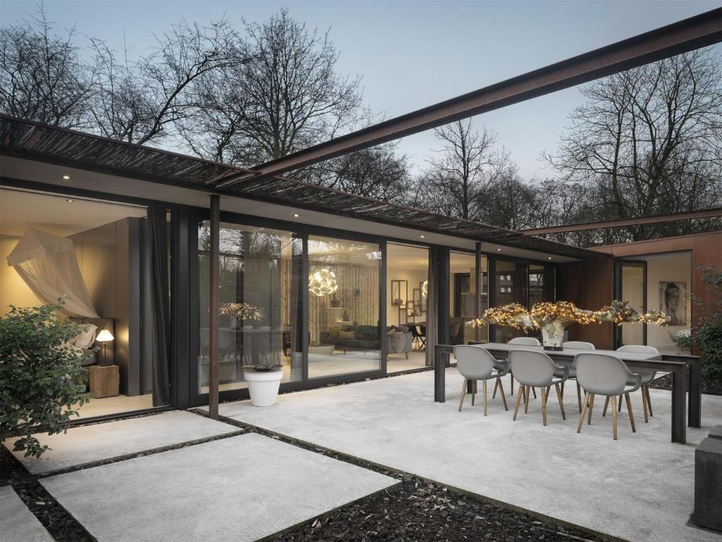an extension of a house with a dining table and chairs at Wellness Villa with Private Sauna in Oosterhout