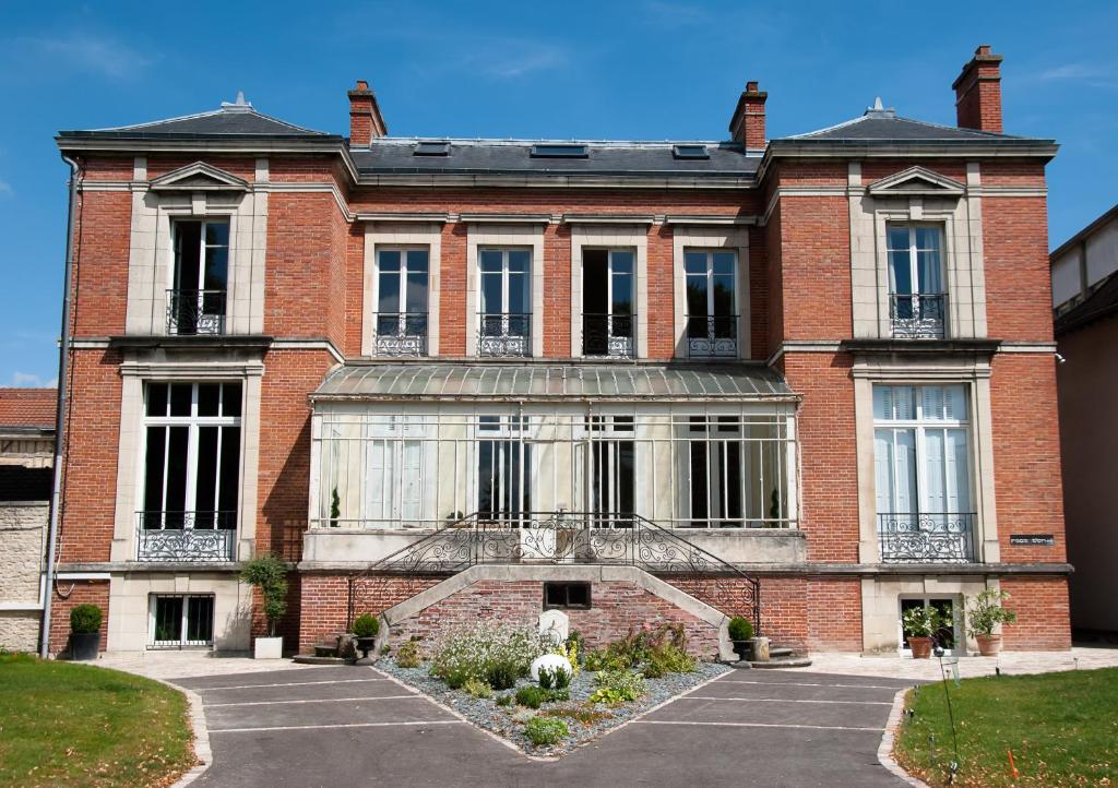duży ceglany budynek z mnóstwem okien w obiekcie Maison M Troyes w Troyes