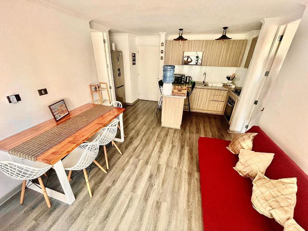 a living room with a table and a red couch at Edificio Lynch- Sector Centro Depto Full Equipado 2D2B Estacionamiento in Iquique
