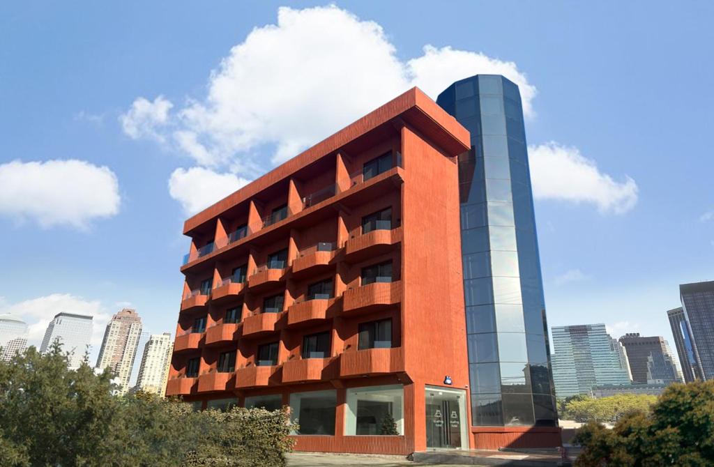 a tall red building with a tall city in the background at Bluefrog Hotel in Incheon