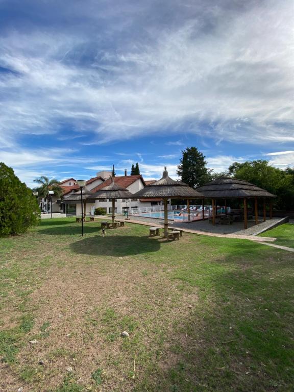a group of picnic tables in a park with a building at Posada Merlo in Merlo