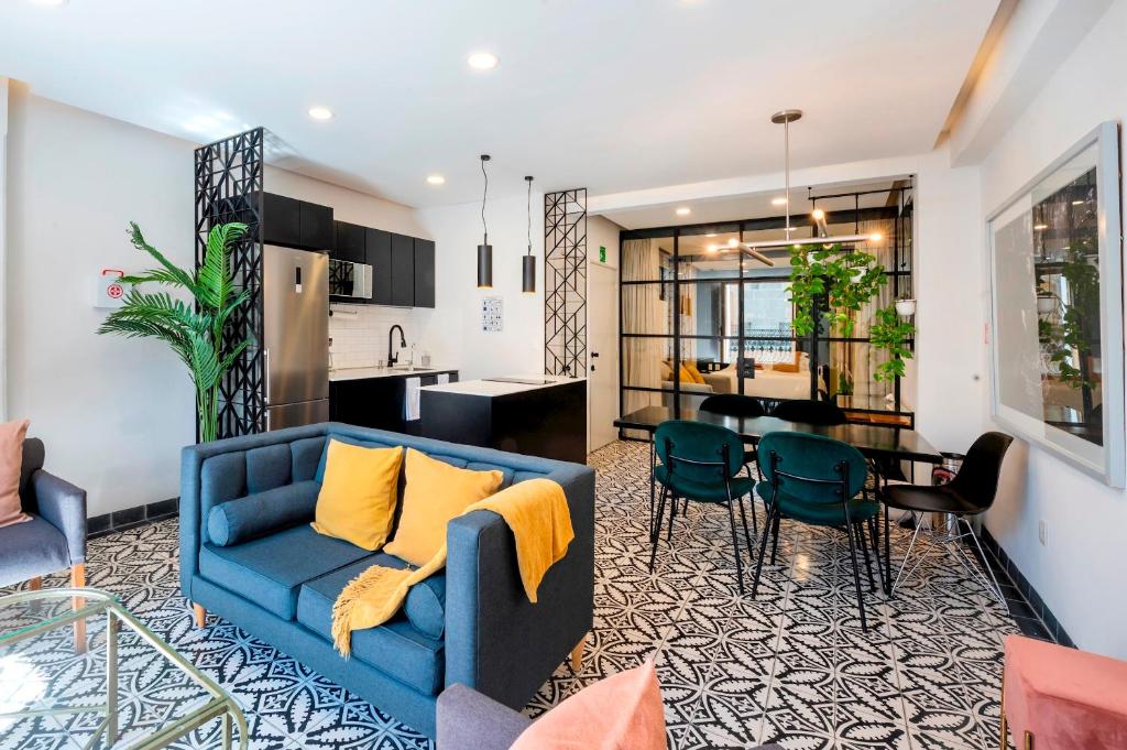a living room with a blue couch and a kitchen at INDEPENDENCIA 2 · Small and Modern Apt for four in Oaxaca City