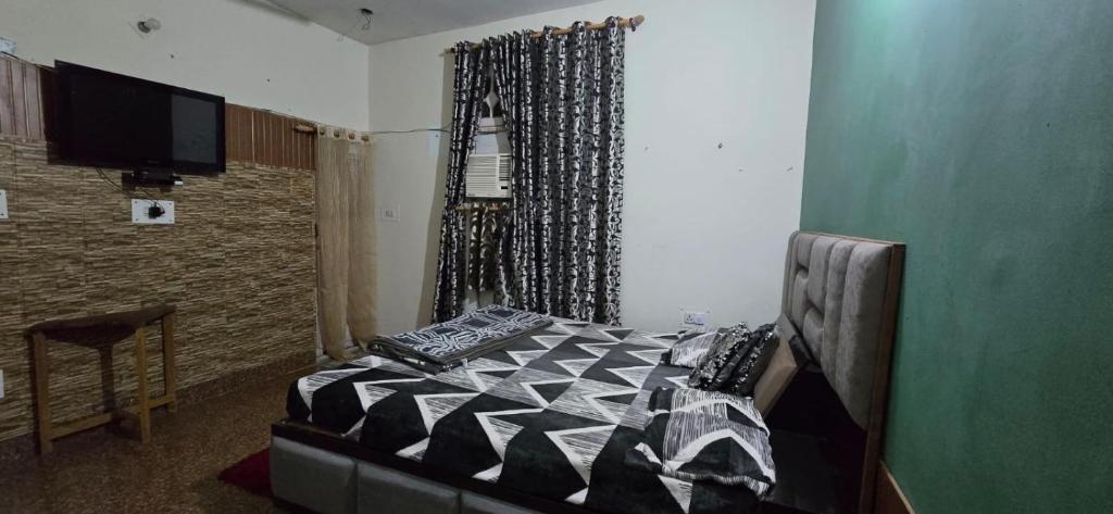 a bedroom with a bed and a television in it at Home stays in Jammu