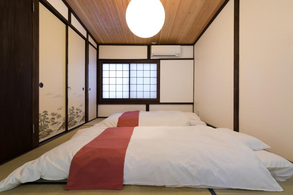 a bedroom with a large bed with a large window at Kyotoya Tsuki no Yu Bettei in Kyoto