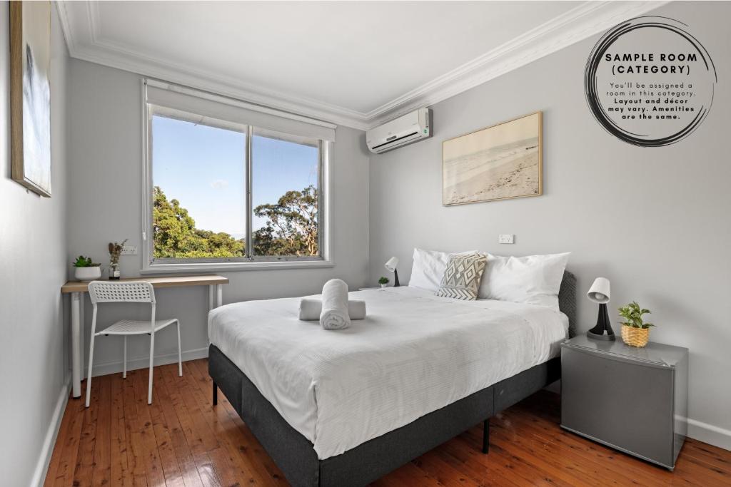 a bedroom with a bed and a desk and a window at Light & Simple Double Room - Peakhurst Area - Shared Bathroom in Peakhurst
