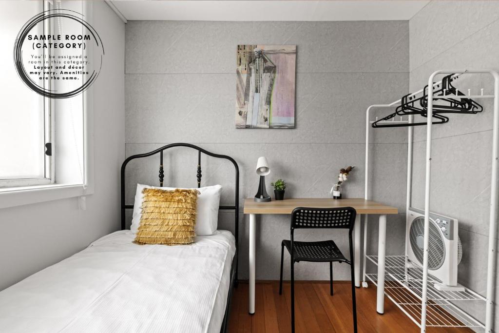 a bedroom with a bed and a table and a desk at Light & Simple Single Room - Peakhurst Area - Shared Bathroom in Peakhurst