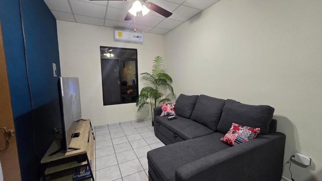 a living room with a couch and a tv at Casa Moderna y Elegante in Santa Ana