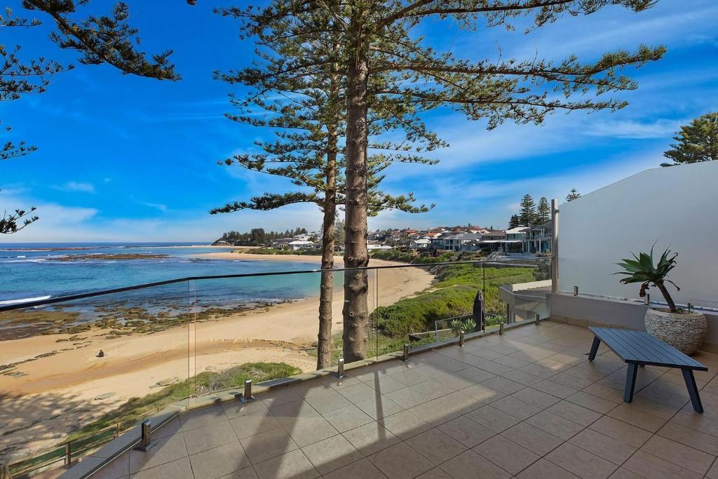 a view of the beach from the balcony of a house at Ocean Pines Apartment 5 in The Entrance