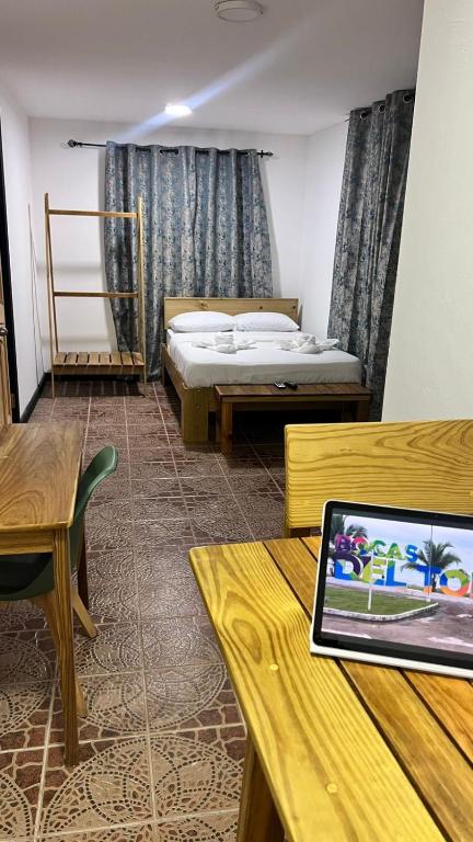 a room with two beds and a laptop on a table at Oasis Town in Carenero