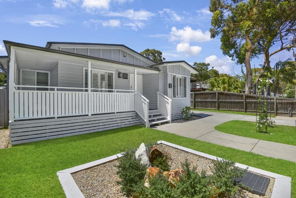 a modular home with a garden and a yard at Margaret's Hamptons Beach House in Hawks Nest